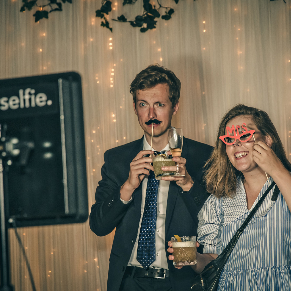 Bryllupsgæster har det sjovt med photobooth, festlige rekvisitter og drinks til bryllupsfest på Sonnerupgaard Gods.