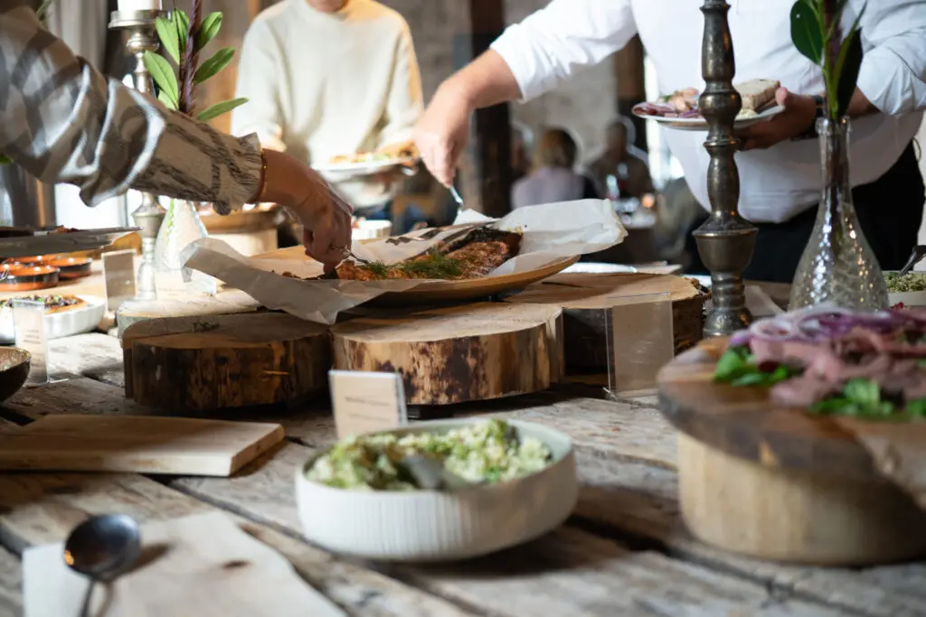 Buffet med servering af varme retter og salater i rustikke omgivelser – gastronomisk oplevelse på Sonnerupgaard Gods
