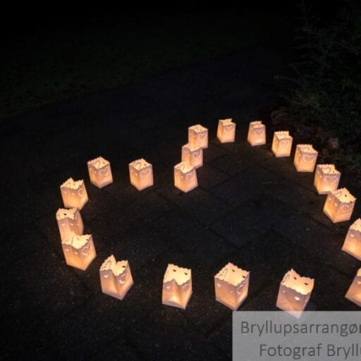 Små lanterner på jorden med levende lys i til bryllup