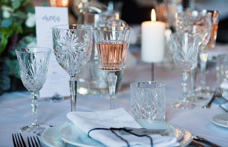 Detaljer fra bryllupsbord med service og fine krystalglas