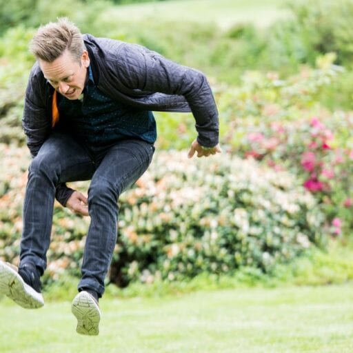 Mand hopper ved aktivitet i grønt parkområde