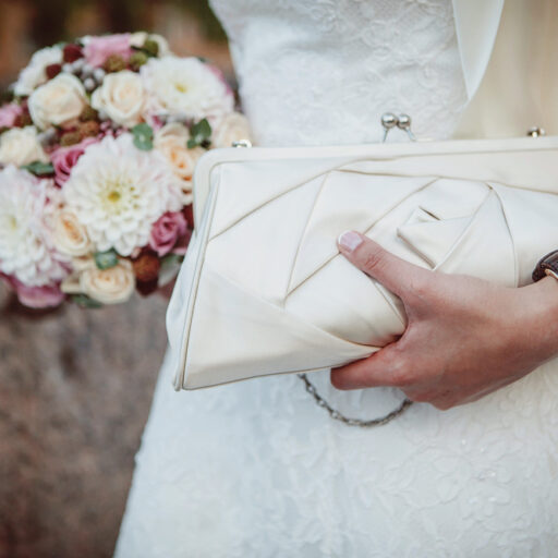 Brud med brudebuket og hvid håndtaske