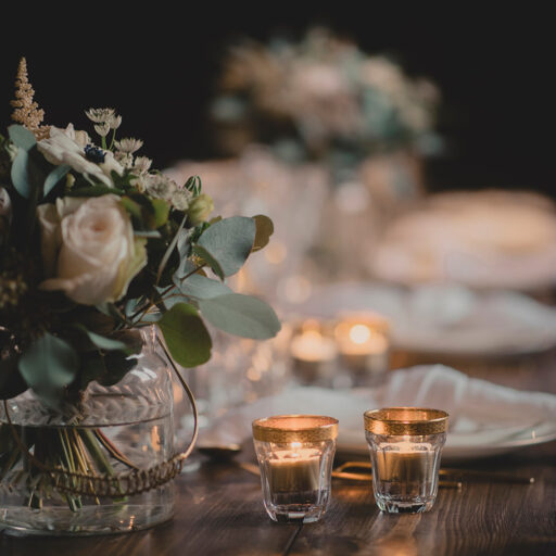 Borddækning bryllup med blomster, levende lys og hørservietter