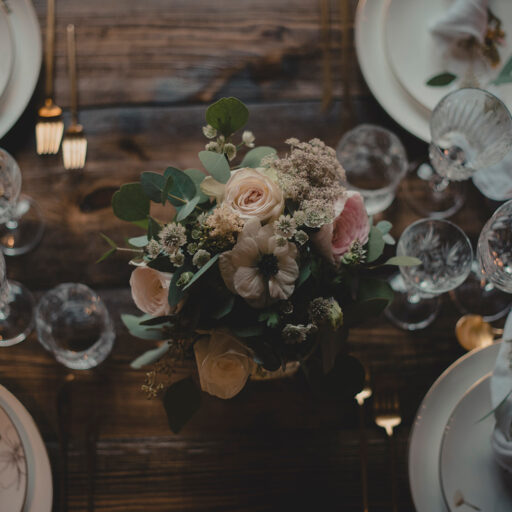 Borddækning med centerpiece af blomster og tallerkener med blomstermotiv