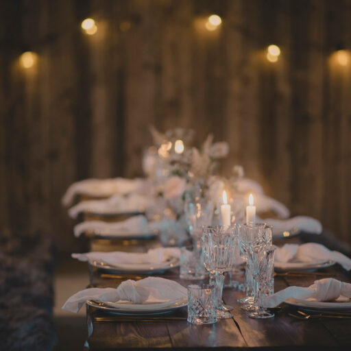Plankebord til bryllup med hørservietter, krystalglas og levende lys i 1877-Laden på Sonnerupgaard