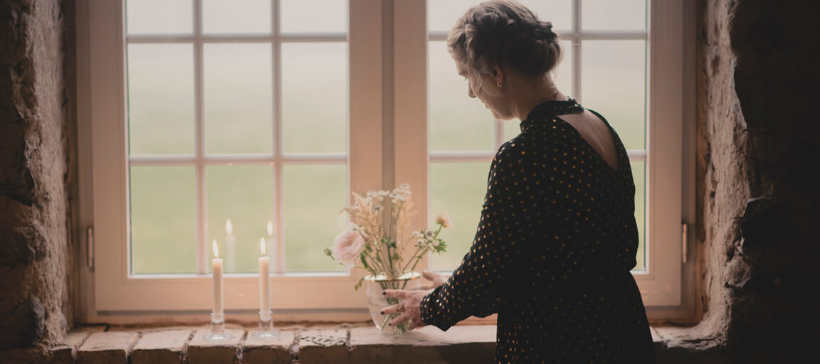 Maria Lyng bryllupsarrangør sætter blomster og levende lys i rustik vindueskarm i 1877-Laden