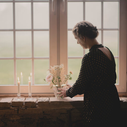 Maria Lyng bryllupsarrangør sætter blomster og levende lys i rustik vindueskarm i 1877-Laden