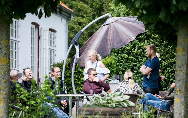 kollegaer hygger på terasse og drikker øl til en sommerfest