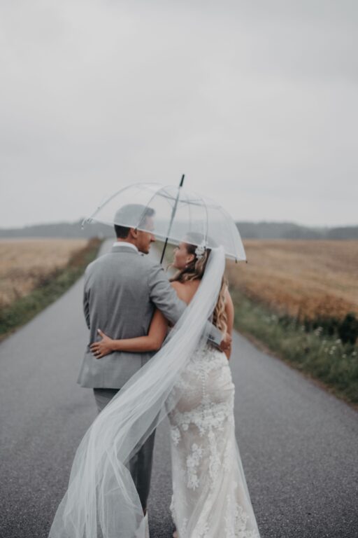 Pernille & Niklas' går i regnen under paraply